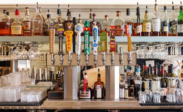 Bar with a row of beer taps and shelves of liquor bottles