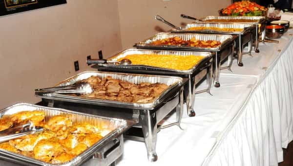 An assortment of catering trays with hot foods on display