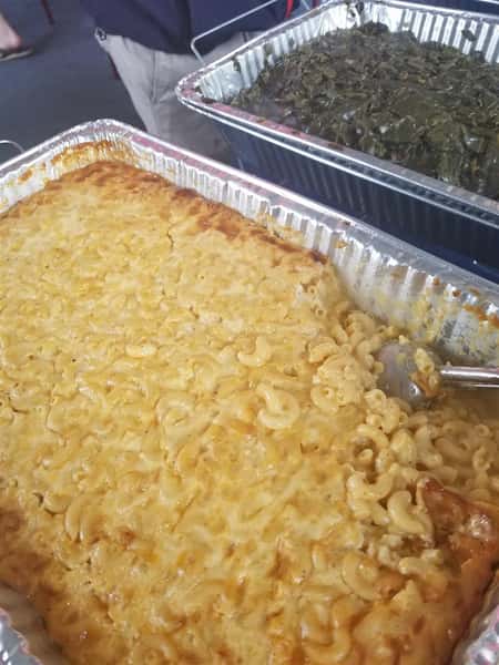 Mac and Cheese in a tray with a serving spoon in it