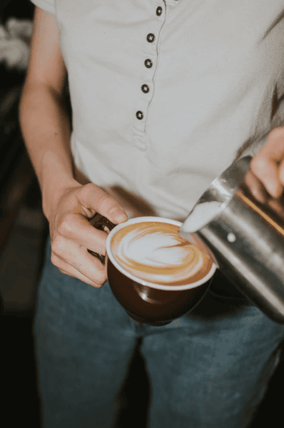 person pouring latte