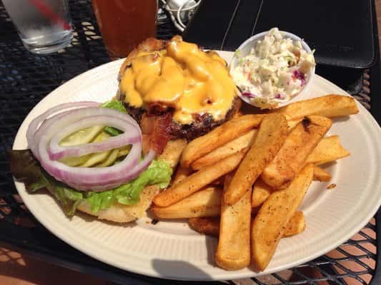 Open faced cheeseburger served with French fries, and coleslaw