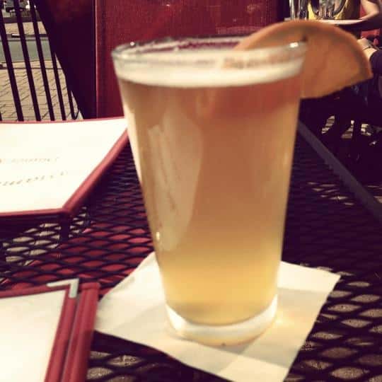 A glass of beer served with a slice of lemon