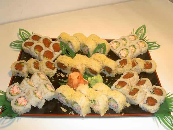 A tray of assorted sushi rolls with wasabi and pickled ginger.