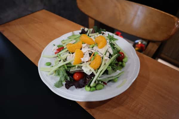 Fresh salad with chicken, mandarin slices, cherry tomatoes, and mixed greens