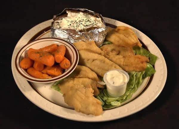 Fried lake perch pieces served with a jacket potato wrapped in foil and a side of baby carrots with a dipping sauce