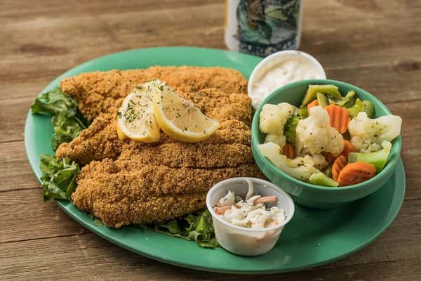 Fried chicken cutlets with a side of vegetables and coleslaw