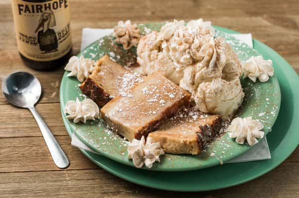 3 Pieces of bread pudding with a side of vanilla ice cream and whipped cream topped with cinnamon