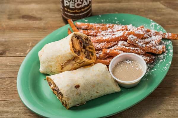 Steak and cheese in a wrap with a side of sweet potato fries