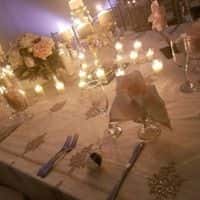 Wedding tables set up with glass wear and dish wear with candles with centerpiece in the middle