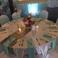 Wedding tables set up with glass wear and dish wear with candles with centerpiece in the middle