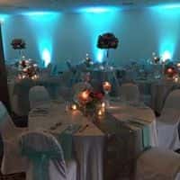 Wedding tables set up with glass wear and dish wear with tall floral centerpieces