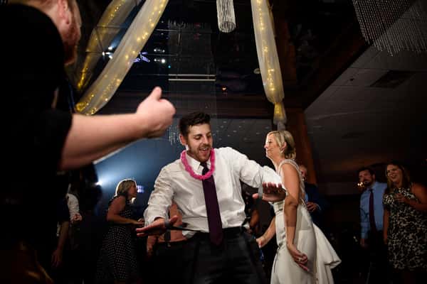 A dancing man with the bride in the background.