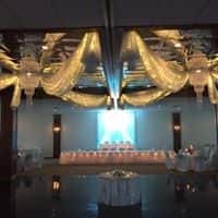 Wedding and wedding party table in front on dance floor with blue lighting