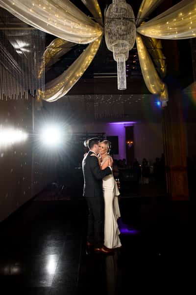 The bride and groom dancing underneath a spotlight.