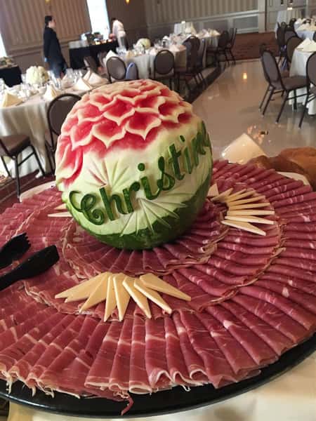 Carved watermelon on to of a meat and cheese platter