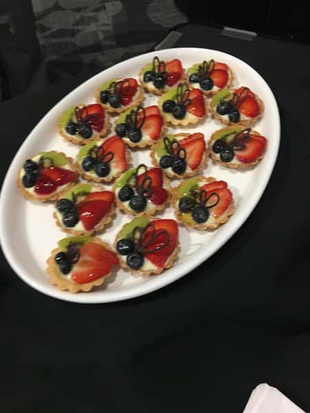Fruit tart with strawberries, kiwi, blueberries and custard on a platter