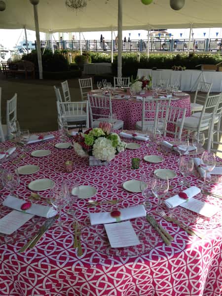 Wedding tables set up with glass wear and dish wear with candles with centerpiece in the middle