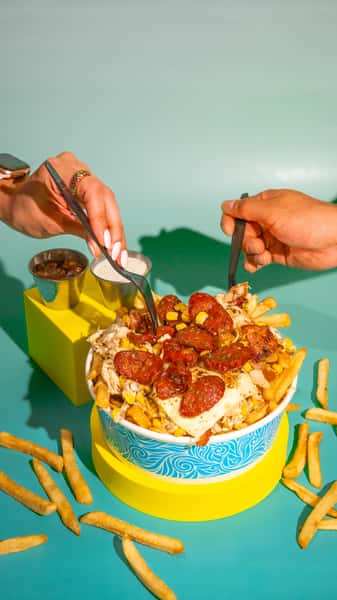 Our famous Crazy fries, topped with a mix of shredded chicken in sauce, smoked bacon bits, grilled onions, roasted corn, melted cheese, and chorizo! Add some pineapple and Apto sauce, and its flavor will blow you away. Nuestras famosas Crazy Fries, cubiertas con una deliciosa mezcla de pollo desmenuzado en salsa, trozos de tocino ahumado, cebollas asadas, maíz rostizado, queso derretido y chorizo. ¡Agrega piña y salsa Apto para una explosión de sabor inolvidable!