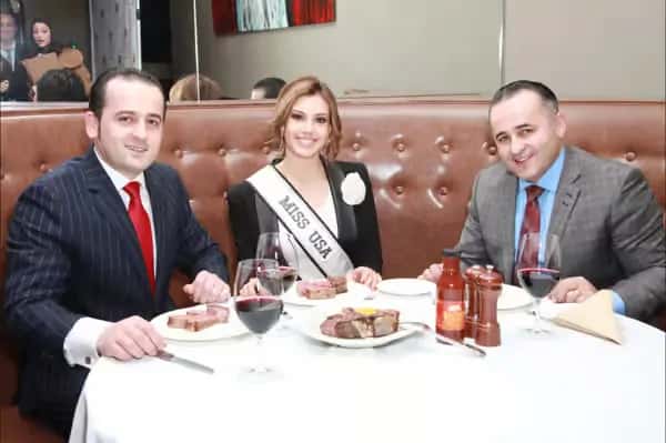 Miss USA and two gentlemen dining at Empire Steak House