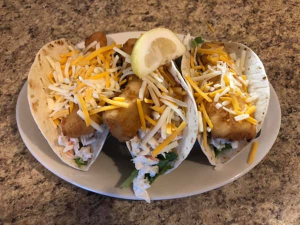 three Fish Tacos with shredded cheese