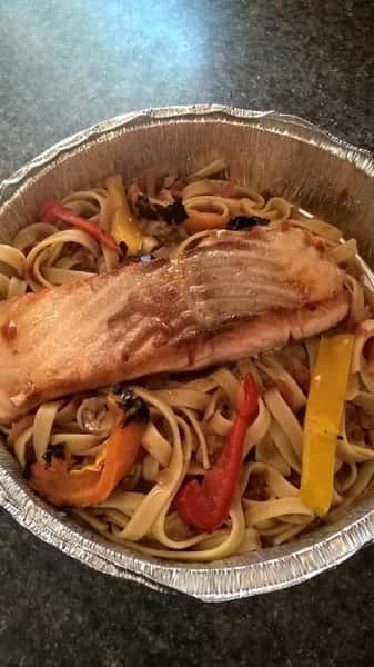 cooked salmon over a bed of pasta