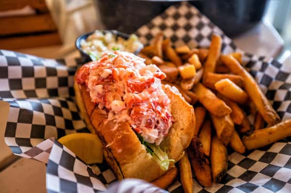 lobster roll in a basket with fries