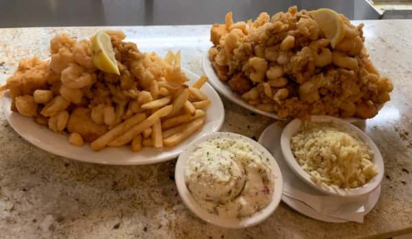 two fried clam dishes with mashed potato and rice sides