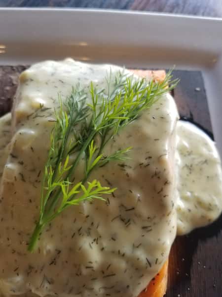 piece of salmon with dill sauce