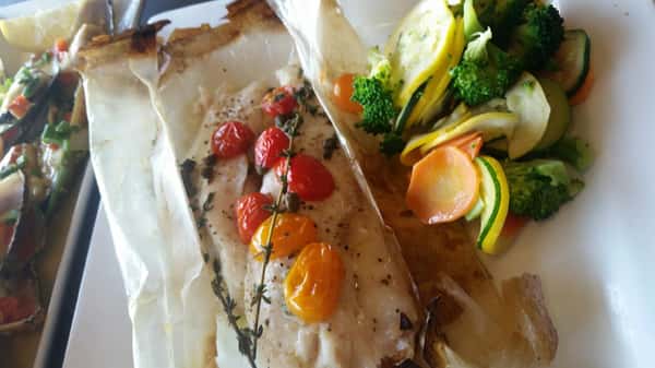 fish dinner with cherry tomatoes, creamy sauce, and steamed vegetables