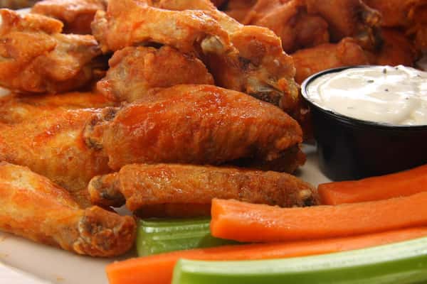 Assortment of buffalo wings with celery and carrots with dipping sauce