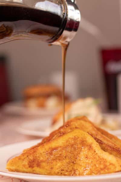 French toast with syrup being poured over the top