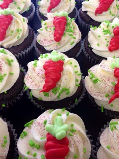 Chocolate cupcakes with white frosting and a carrot on them