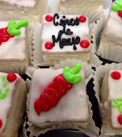 White mini cakes topped with red decoration and chocolate letters