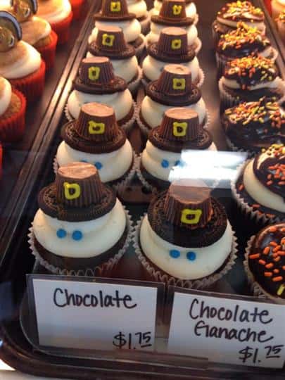 Cholocate cupcakes topped with white frosting and chocolate