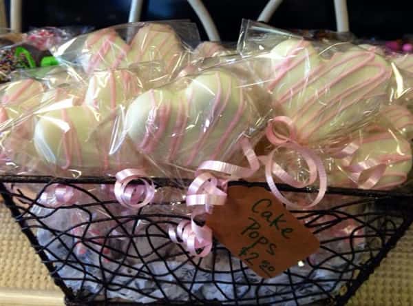 A basket of white heart cake pops with pink stripes