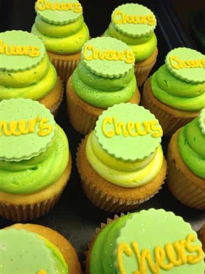 Cupcakes with yellow frosting topped with light green sugar and yellow letters