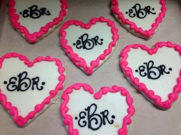 White and pnk cookies in heart shapes topped with chocolate letters