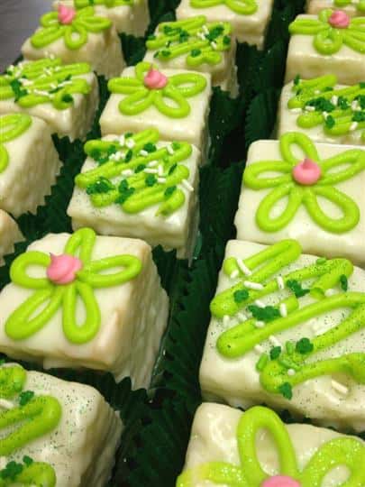 Cream mini cakes topped with light green and pink decoration