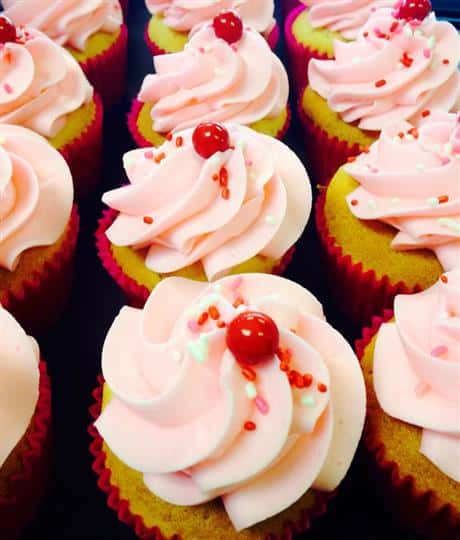 Cupcakes with pink frosting and red decoration