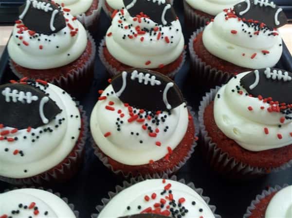 Cupcakes topped with white chocolate and a dark chocolate football ball