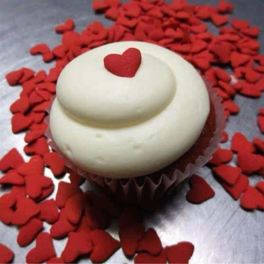 Cupcake topped with white frosting and a red heart