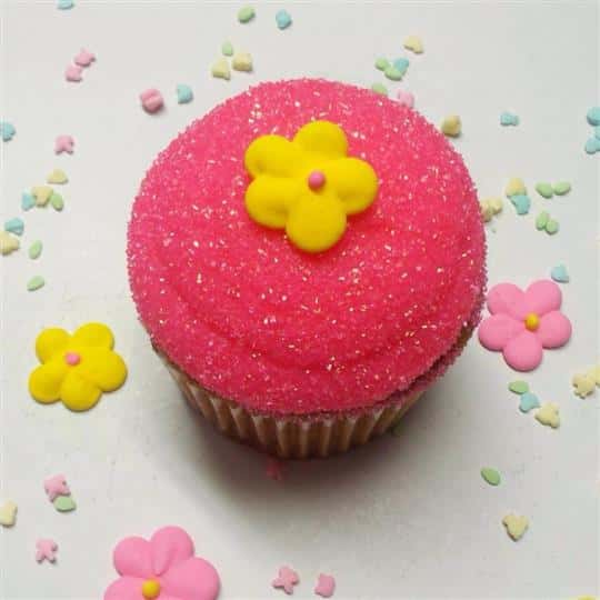 Cake Pop topped with with pink marshmallow and a yellow sugar flower