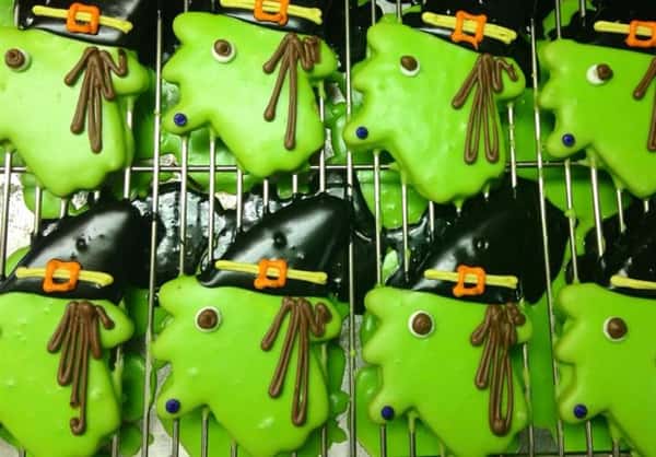 Light green covered cookies topped with chocolate hats and funny decoration