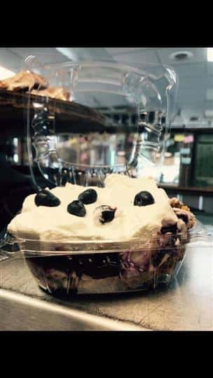 blueberry pastry in a plastic container topped with whipped cream