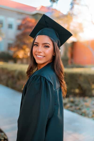 Smiling female graduate in a cap and gown