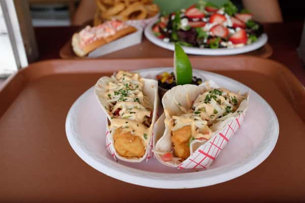 fish tacos in a basket with a lime wedge