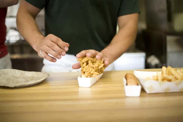 hands packing in onion rings in a basket