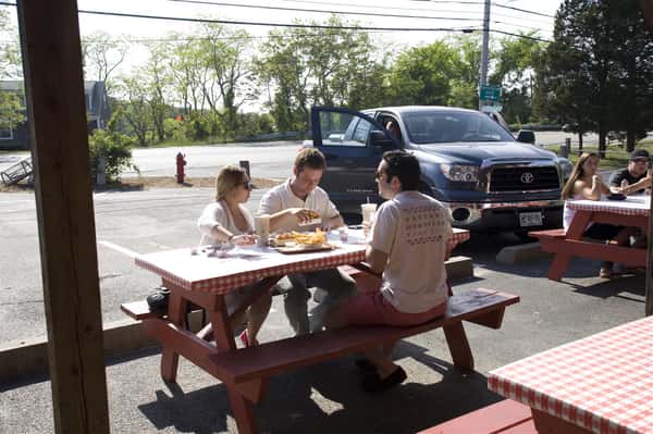 three people sitting at a picnic table