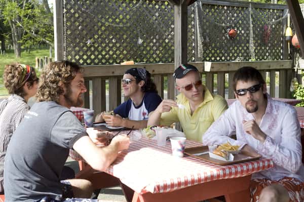 a group of men eating at a picnic table