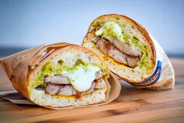 The #1 Best Seller Sandwich Oven roasted pork, mozzarella cheese, ham, pickles, mustard and green sauce. Served on a ciabatta bread.